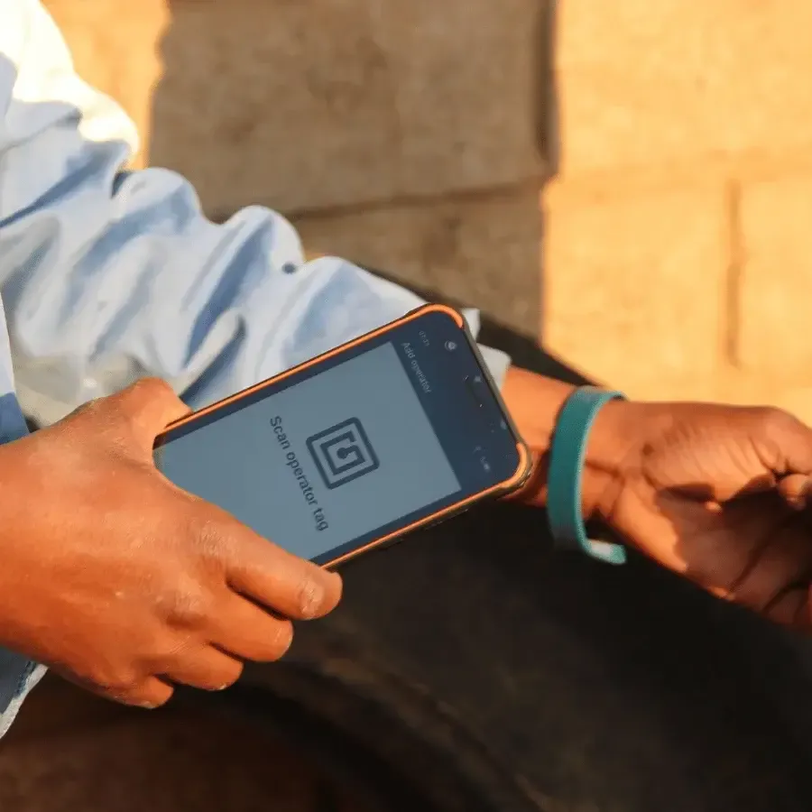 Rugged handheld device scanning an employee RFID wrist tag for clocking